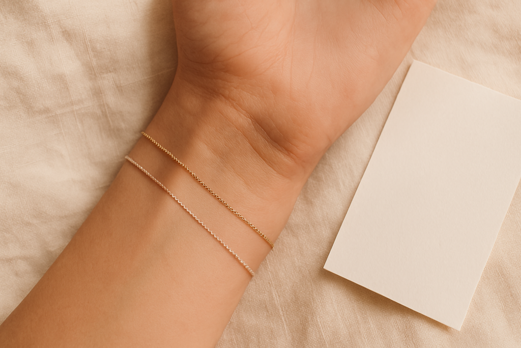 Bare wrist next to gold and silver jewelry on cream linen showing skin undertone